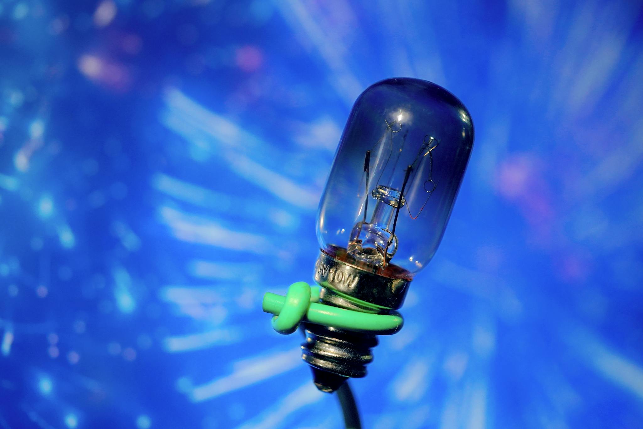 Macro shot of a light bulb with a creative blue bokeh background. Ideal for lighting concepts.