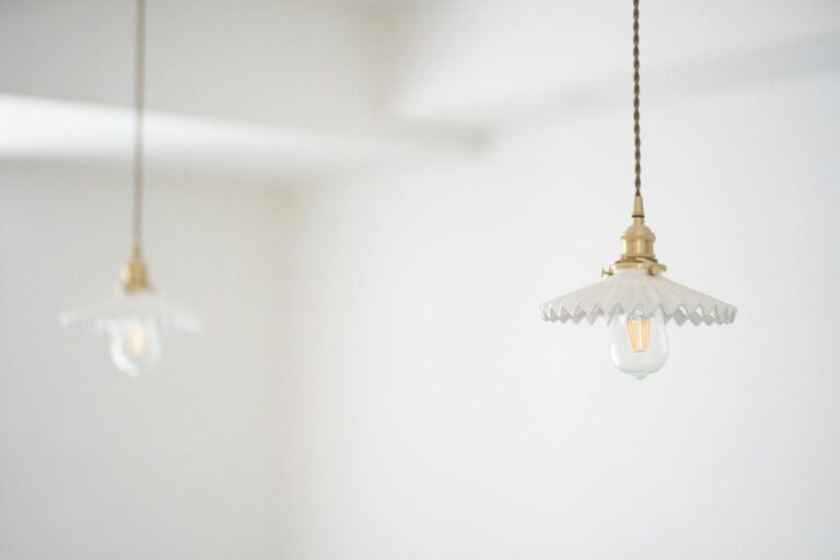 Elegant vintage-style hanging light bulbs in a minimalistic white indoor setting.